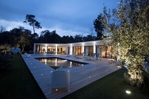 A modern house with a swimming pool, outdoor seating, and a well-lit patio area. - THE DUNE VILLA PLATIN ST PALAIS SUR MER (Saint-Palais-Sur-Mer)