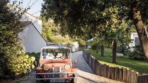 A vintage red car parked on a gravel path in a residential area with houses and greenery. - THE DUNE VILLA PLATIN ST PALAIS SUR MER (Saint-Palais-Sur-Mer)