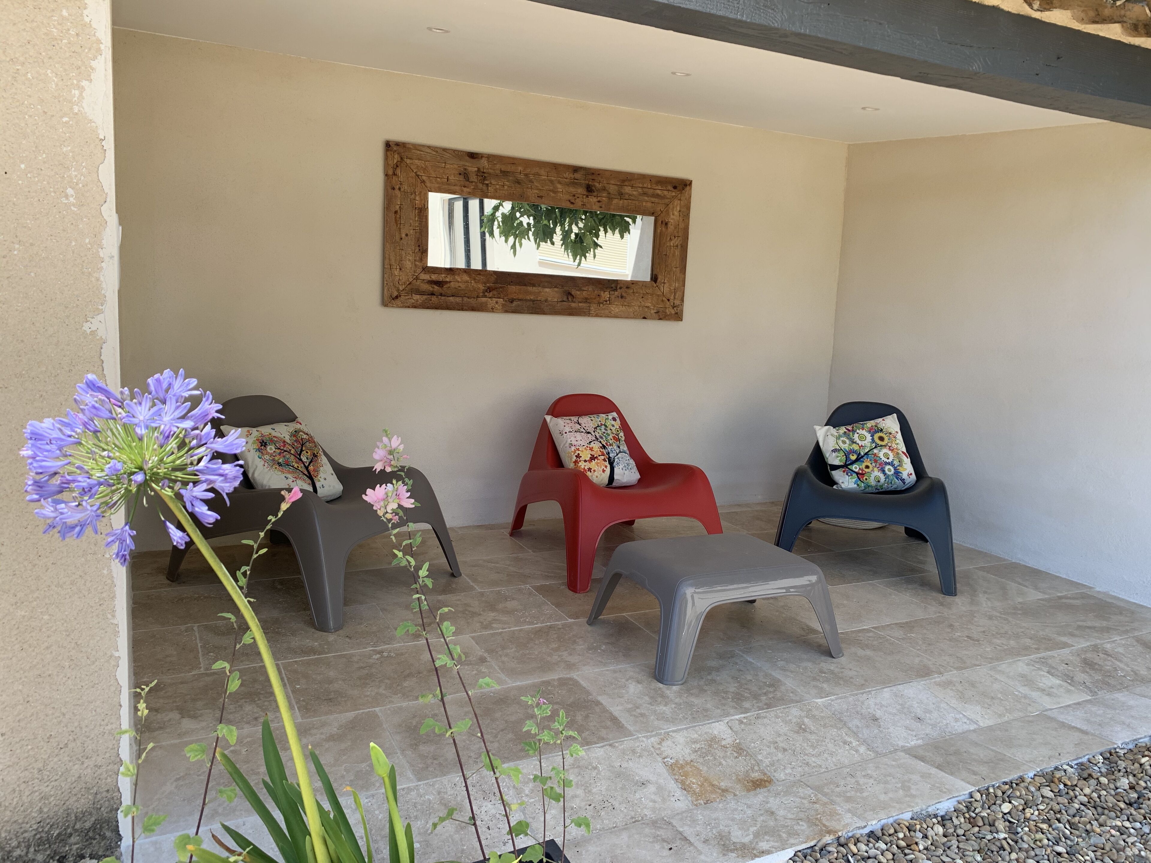 A patio area with three chairs, a small table, and a potted plant.