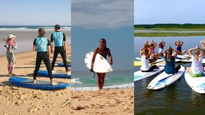 Eine Strandansicht mit Personen auf Surfbrettern und einer Gruppe, die Yoga auf schwimmenden Plattformen praktiziert.