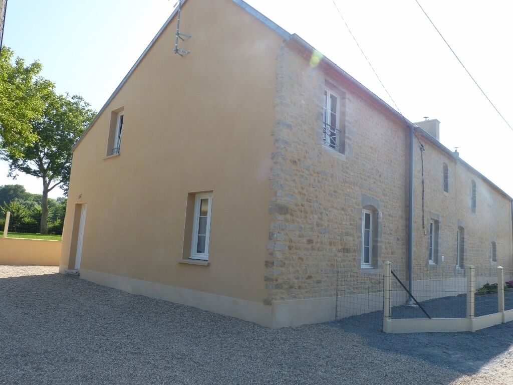 A two-story building with a stone facade and a flat roof.