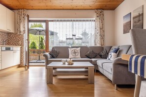 Un salon avec un canapé, une table basse et une vue sur l’extérieur.