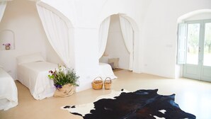 A bedroom with two beds, a cowhide rug, and a potted plant.