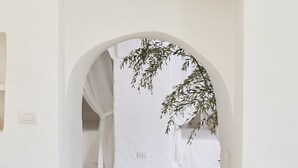 A hallway with a white archway leading to a room.