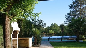 Un patio cubierto con un sendero que lleva a una piscina.