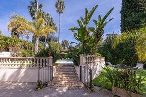 A garden with a pool, palm trees, and a staircase leading to a pool area. - Villa in Cannes 300 meters form the sea - 5 bedrooms, garden and swimming pool (Cannes)