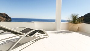 A balcony with a white chair and a potted plant, overlooking a coastal view. - Ranked among the 21 most pleasant villas in Andalusia by the TIMES in 2023 (Las Negras)
