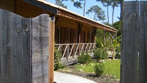 A wooden building with a covered porch and a curved pathway leading to it.