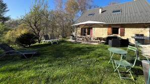 Una casa de piedra con techo inclinado y un patio amoblado al aire libre.