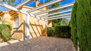 A courtyard with stone paving, a pergola, and a well-maintained hedge. - Oliva Nova Golf pool, private garden, ADSL-Wifi, TV SAT and offerts 2013 (Oliva)