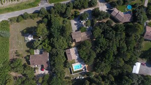 An aerial view of a residential area with multiple houses, a swimming pool, and a road.