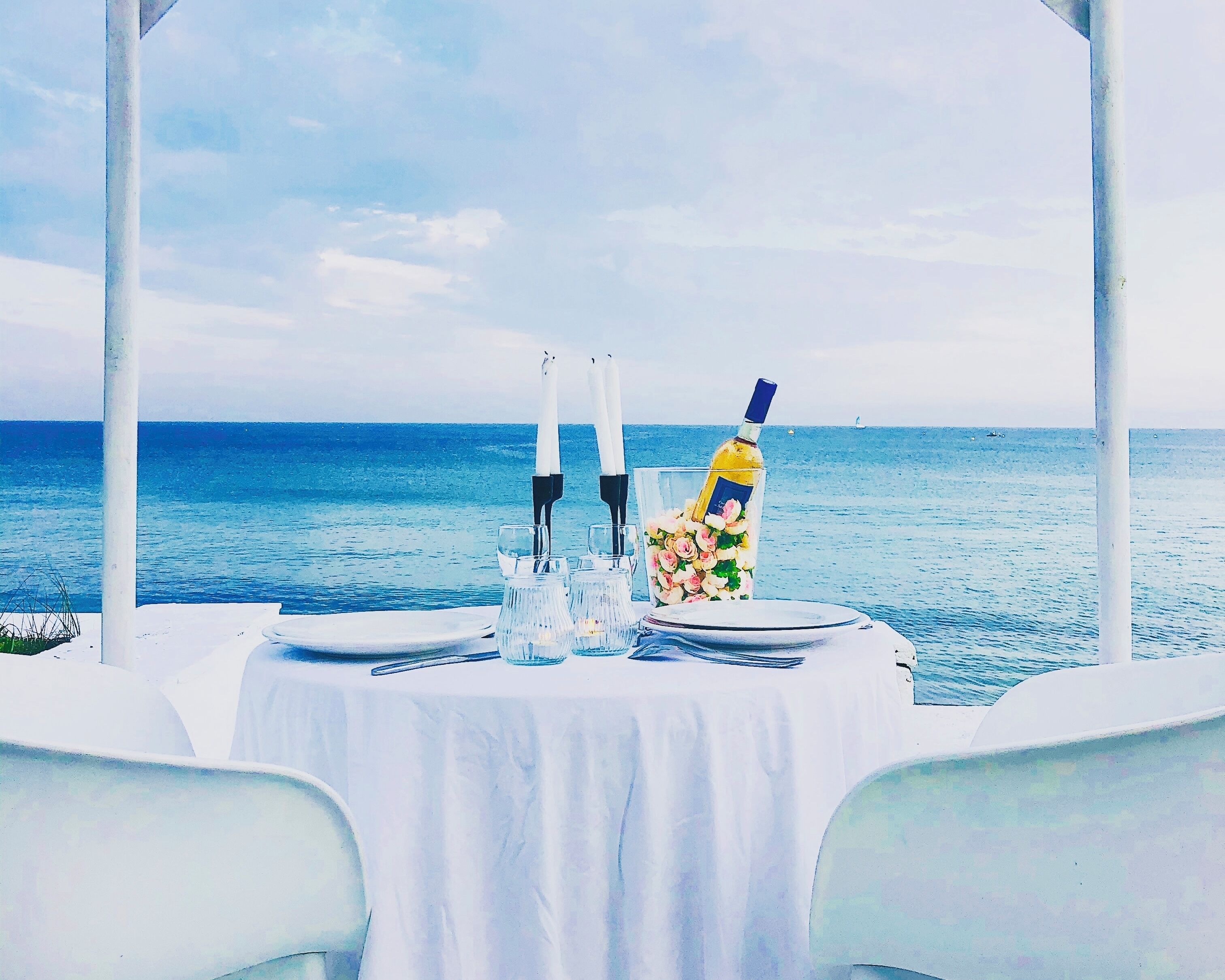 A table set for two with a view of the sea.