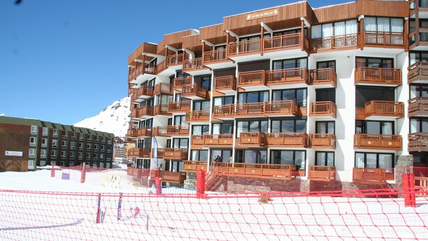A multi-story hotel with balconies, large windows, and a snowy mountain in the background. - Roc de Peclet apartment 41 m², South, Foot of the slopes, Heart Station (Les Belleville)