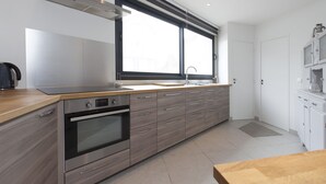 Eine moderne Küche mit großem Fenster, Edelstahlgeräten und einer Holzausziehtafel.