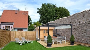 A backyard with a wooden deck, a pergola, and a dining area with chairs and a table. - Contemporary house 10 people with sauna and Spa (Kaysersberg Vignoble)