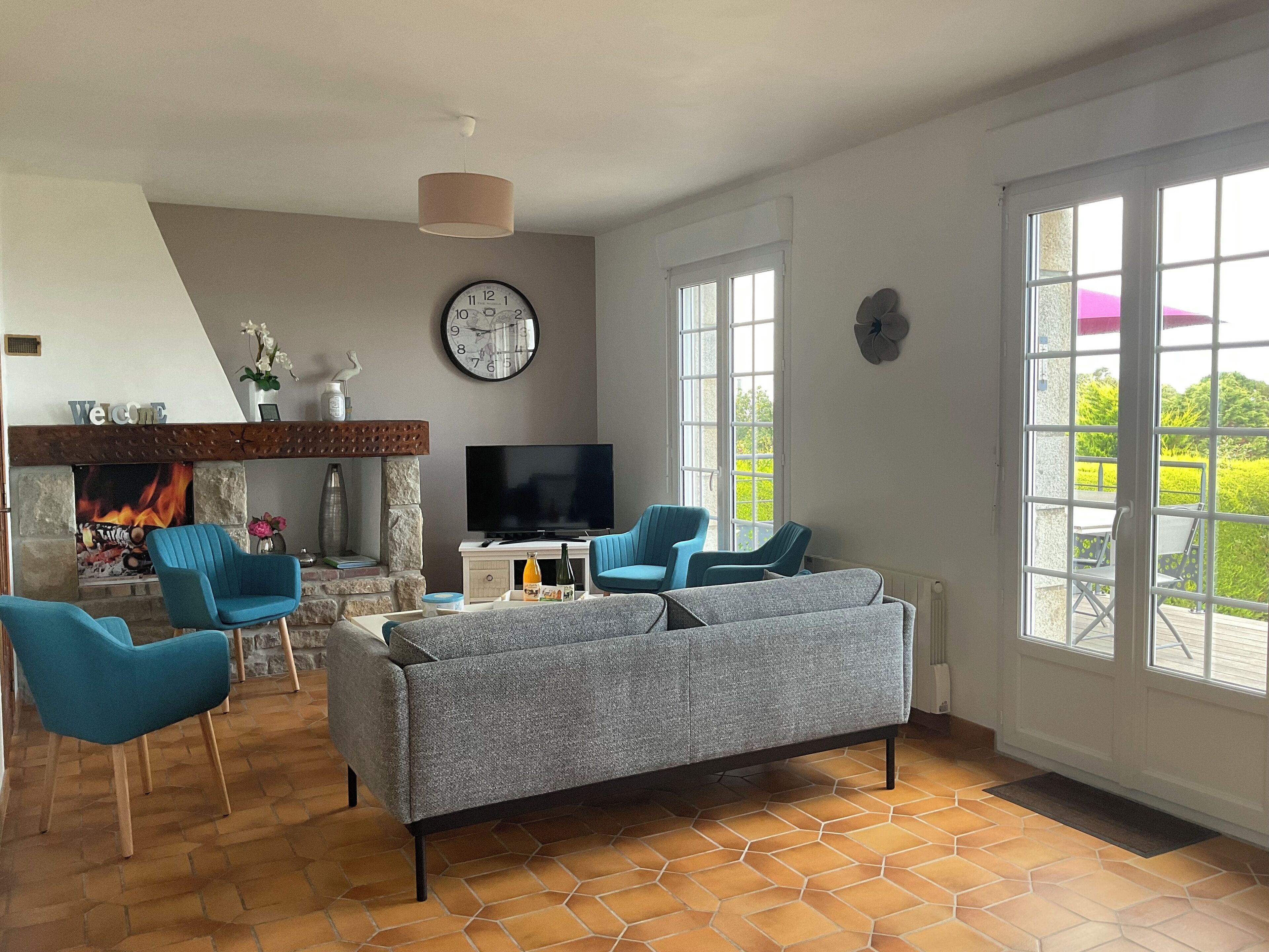 Un salon avec une cheminée, un téléviseur et un canapé.