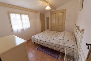 Un dormitorio con cama, armario, ventana y puerta.