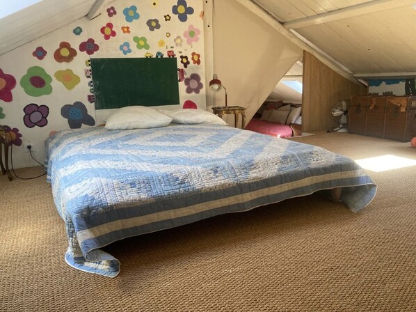 A bedroom with a bed, a green headboard, and a wall decorated with colorful flower stickers. - Stone farmhouse with swimming pool between Avignon and Orange, in Roquemaure (Roquemaure)