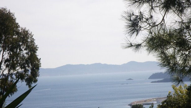 A coastal landscape with a view of the sea, distant mountains, and a variety of trees. - Spacious ground floor of villa, magnificent sea view, terrace , enclosed parking (Le Lavandou)