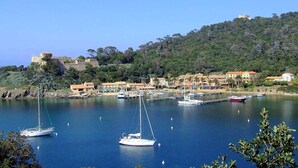 A coastal town with a marina, boats, and buildings on a hillside. - Spacious ground floor of villa, magnificent sea view, terrace , enclosed parking (Le Lavandou)