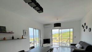 Eine moderne Küche mit Essbereich, einem Fernseher und einer Couch.
