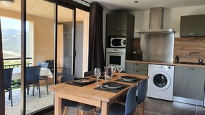 A modern kitchen with a dining area, a washing machine, and a view of the outdoors. - Quiet village, panoramic view, Scandola reserve, warm river Le Fango (Galéria)