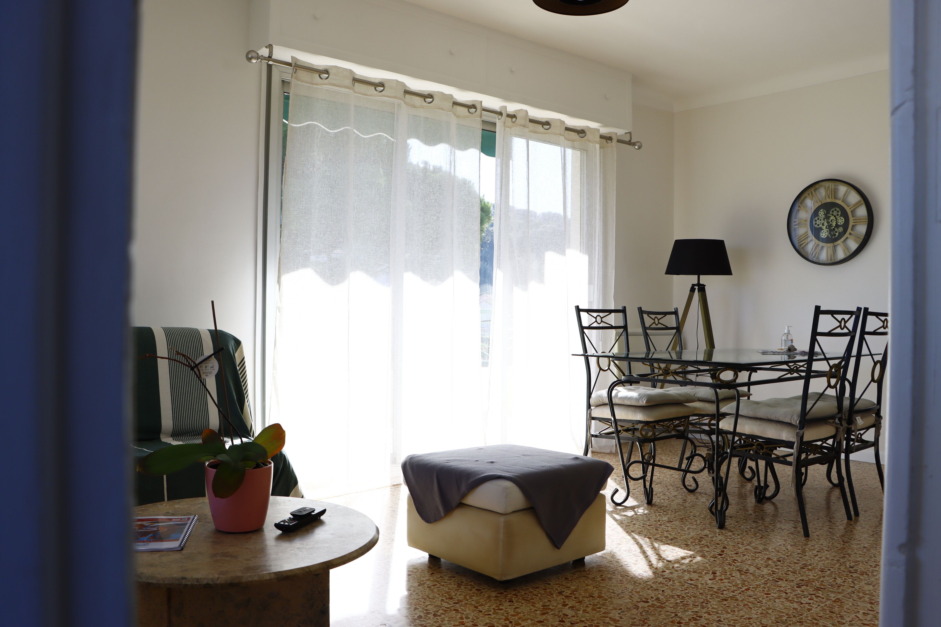 A dining area with a table and chairs, a potted plant, and a lamp.