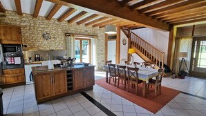 A spacious kitchen with wooden cabinets, a central island, and a dining area with a table and chairs. - Haven of peace, sweet home, swimming pool, 7 beds between Tours and Poitiers (Senillé-Saint-Sauveur)
