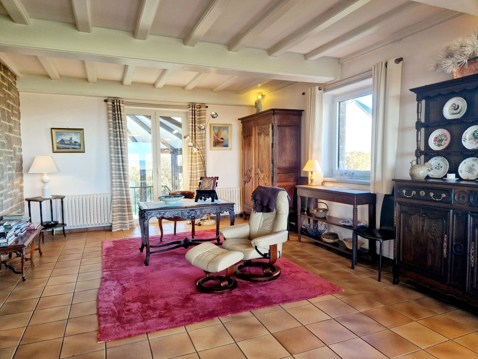 A cozy living room with a fireplace, a dining table, and a comfortable armchair.