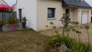 A house with a sloped roof, a small window, and a door. There is a signpost in the front yard. - 3-star seaside villa, sleeps 7, 150 m from the beach and the GR34 trail. Large, enclosed garden (Plounéour-Brignogan-Plages)