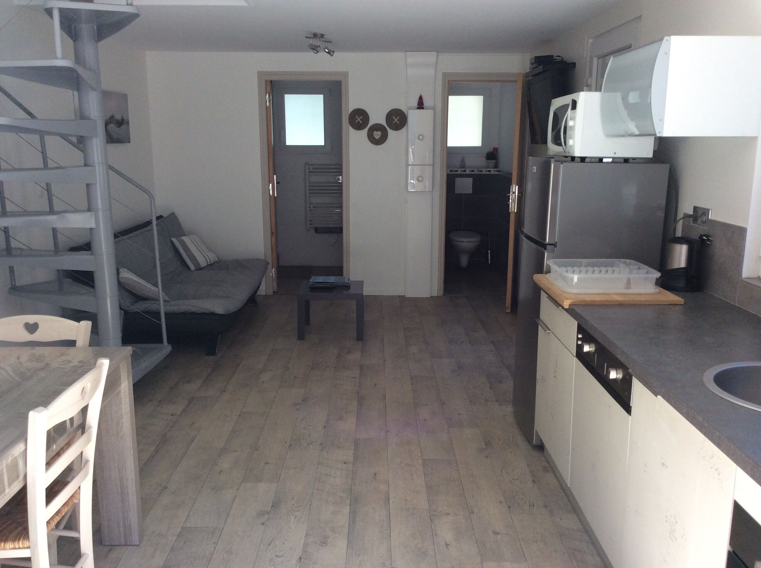Een compacte woonruimte met een kitchenette, een eethoek en een zithoek.
