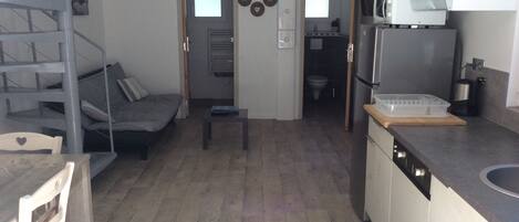 Een compacte woonruimte met een kitchenette, een eethoek en een zithoek.