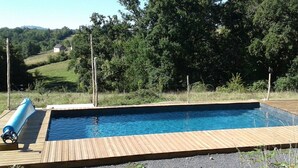 A rectangular swimming pool with a wooden deck, surrounded by a fence and trees. - Promo end of August 25% 3 bedroom cottage of 85m2 with south facing terrace of 60m2  (Saint-Cyr-La-Roche)