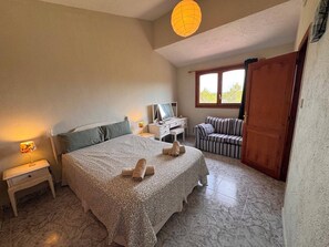 A bedroom with a bed, a desk, a television, a sofa, and a window. - Wonderful country house with private pool (El Perelló)