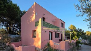 A pink building with a pool, surrounded by rocks and plants. - Wonderful country house with private pool (El Perelló)