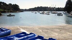 Un port de plaisance avec plusieurs bateaux amarrés et une plage de sable au premier plan.