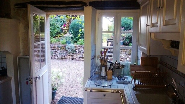 A kitchen with a small sink, a window overlooking a garden, and a door leading outside. - Adorable country house in the heart of a hamlet overlooking the valley (Authiou)