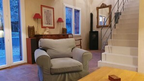 Un salon avec un canapé, une table en bois, une cheminée et un escalier.