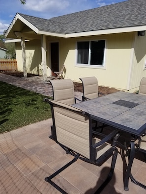 Relax on the patio with a comfortable table and chairs, surrounded by a serene outdoor space.