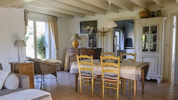 Un coin repas accueillant avec une table et des chaises en bois, une lampe et un buffet contenant de la vaisselle.