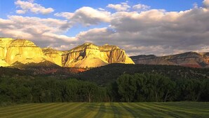 A mountainous landscape with a valley and a field in the foreground. - Relax In Southern Utah's Color Country! (MOUNT CARMEL)