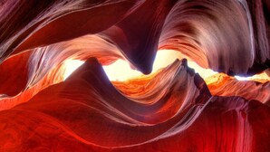 A natural rock formation with smooth, curved surfaces and a bright light source at the center. - Relax In Southern Utah's Color Country! (MOUNT CARMEL)