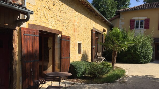 A rustic stone building with wooden shutters and a gravel courtyard. - Beautiful house of 315 m² in a 4000 m² park with swimming pool 3 minutes from Périgueux (Champcevinel)