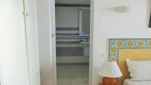 A bathroom with a white door, a sink, and a toilet. There is a lamp on a small table next to the bed. - House with garden beach Scudo (Ajaccio)