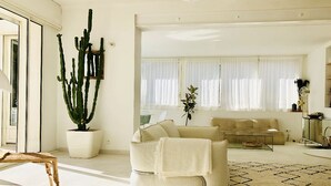 Un salon moderne avec un canapé, une table basse et un cactus.