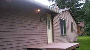 A single-story house with a front porch, a small front yard, and a chimney. - ~ Cozy Creek Side Cabin ~ Nature ~ Peaceful ~ Relax ~Family!  (Hill City)