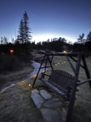 Un entorno rústico al aire libre con un columpio de madera y un camino de piedra.