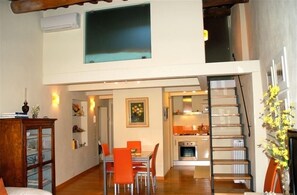 Um apartamento moderno com área de jantar, cozinha e escada.