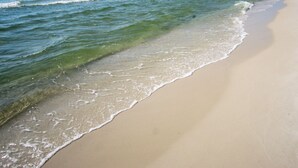 Een strand met helder water en een zandstrand.