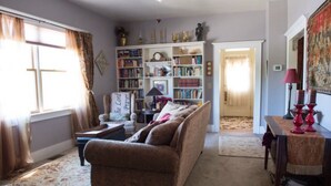 Ein gemütliches Wohnzimmer mit einer Couch, einem Bücherregal und einem Essbereich mit Tisch und Stühlen.